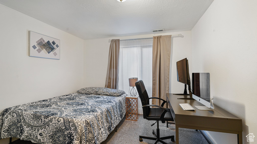 Bedroom featuring carpet flooring and a desk