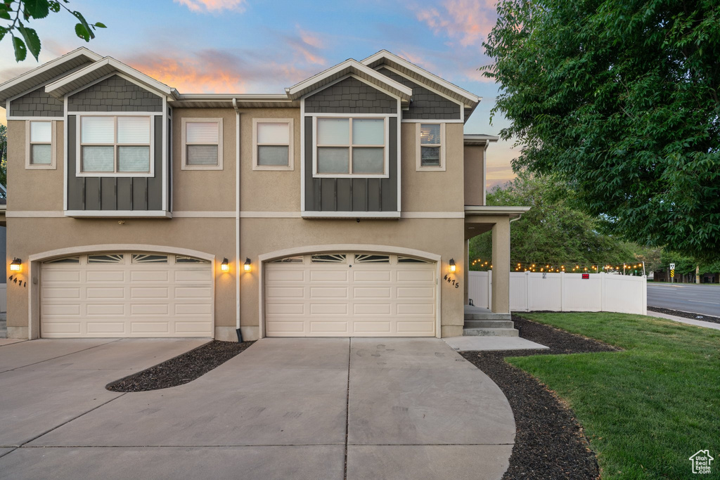 View of front of home with a garage, concrete driveway, and stucco siding