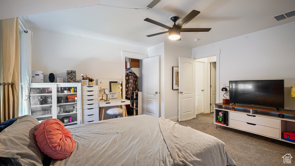 Carpeted bedroom with a ceiling fan