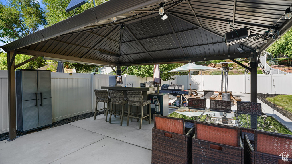 Fenced backyard featuring a patio and a gazebo