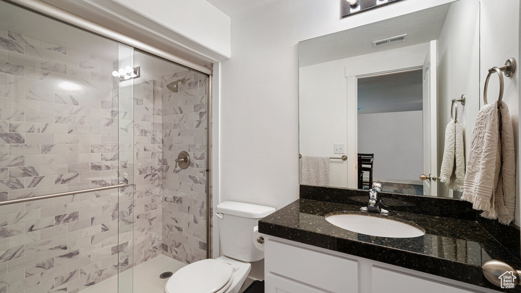 Bathroom with vanity, a stall shower, and toilet