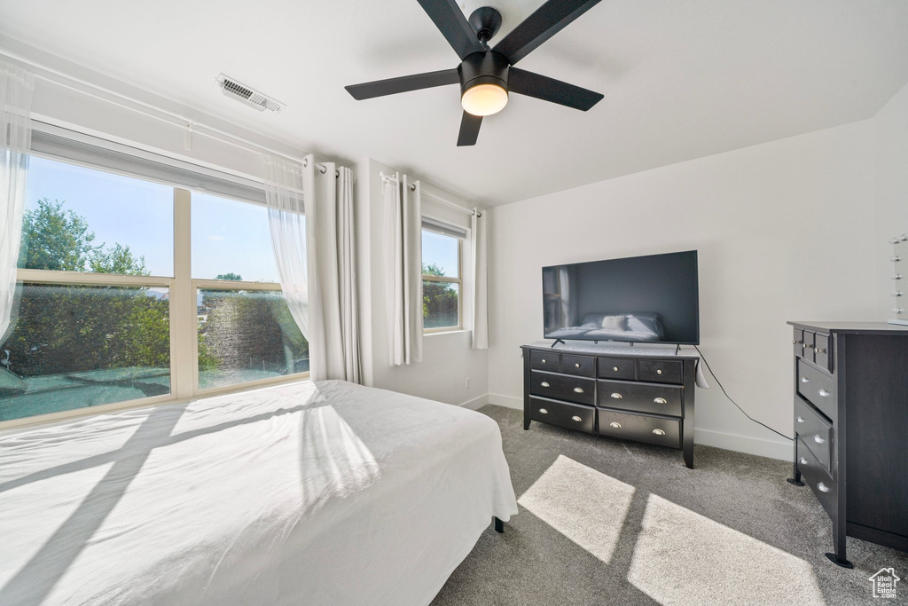 Bedroom with baseboards, ceiling fan, and carpet flooring