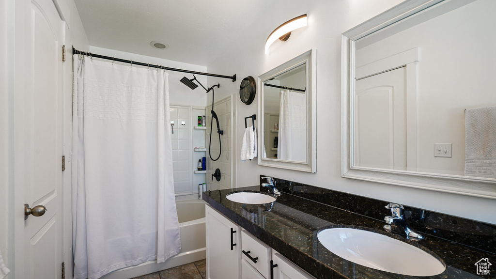 Bathroom featuring double vanity and shower / bath combo with shower curtain