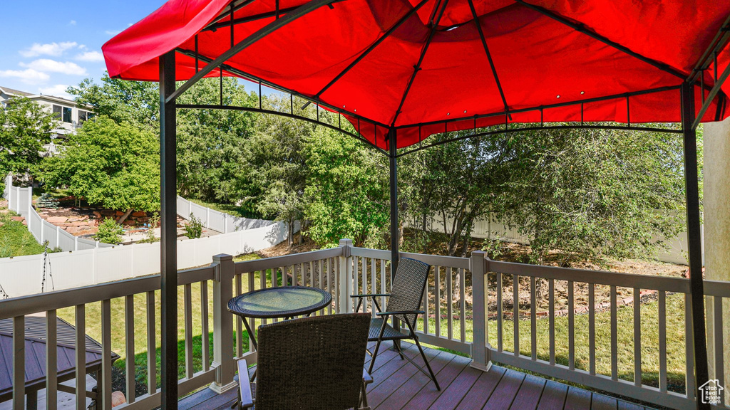 Wooden terrace with a gazebo and a fenced backyard