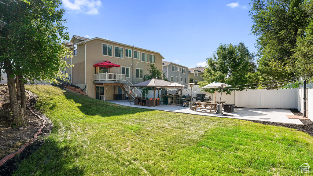 Back of house with a patio area, stucco siding, a gazebo, and a deck