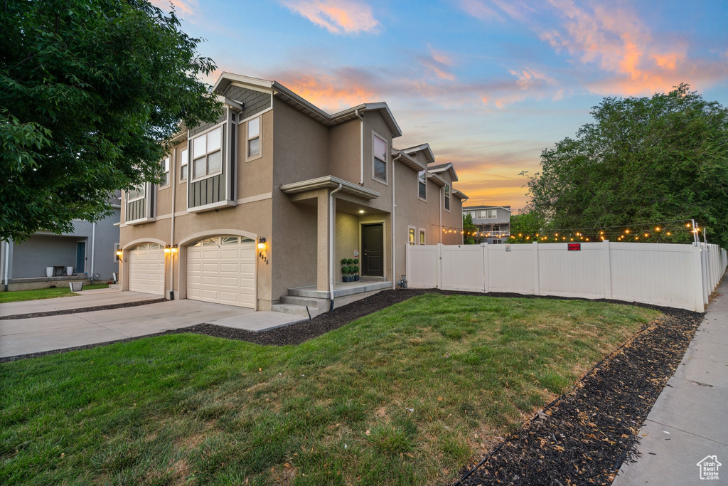 View of side of property featuring an attached garage, driveway, and stucco siding