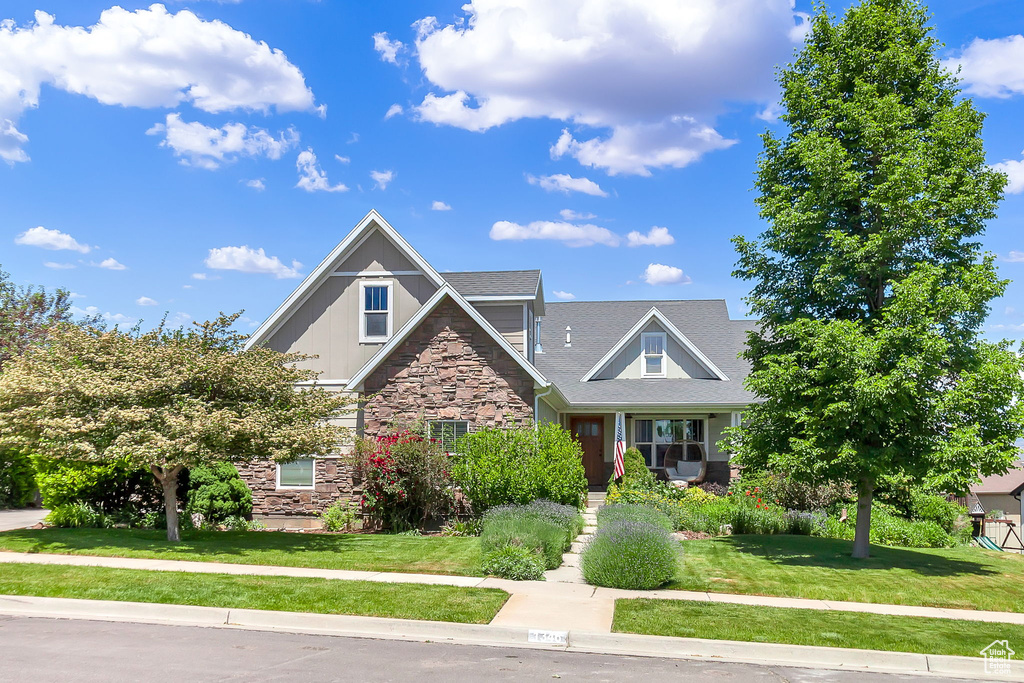 Craftsman-style home with stone siding and a front lawn