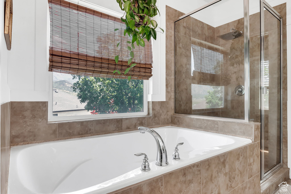 Bathroom featuring a stall shower and a bath