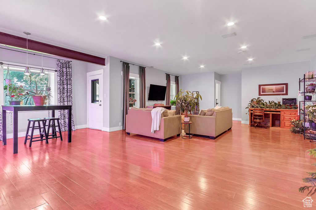 Living room featuring light wood-type flooring, recessed lighting, and baseboards