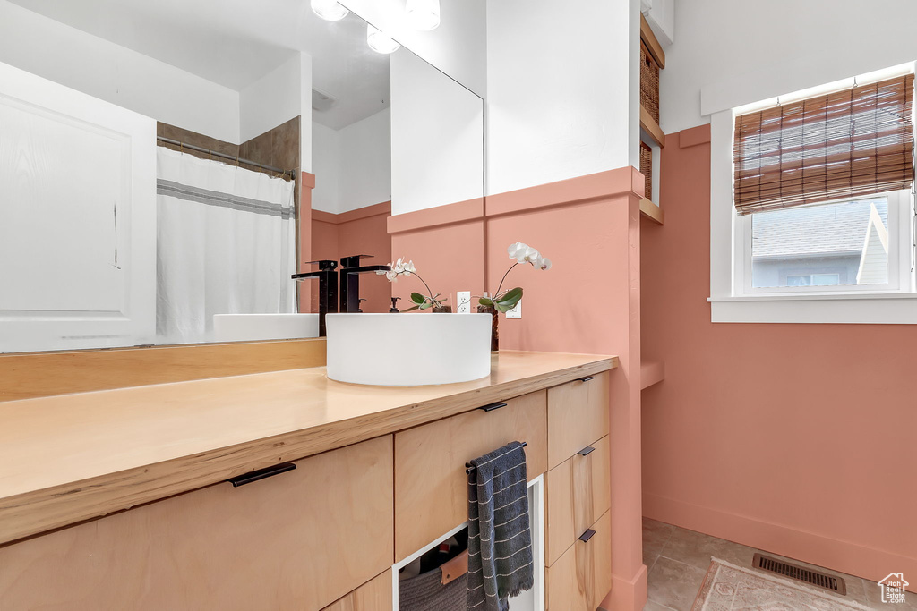 Bathroom with vanity, tile patterned floors, and baseboards