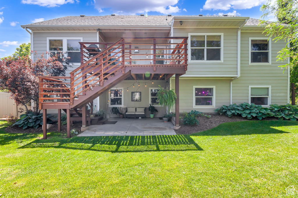 Rear view of house featuring a patio area, a deck, a yard, and stairway