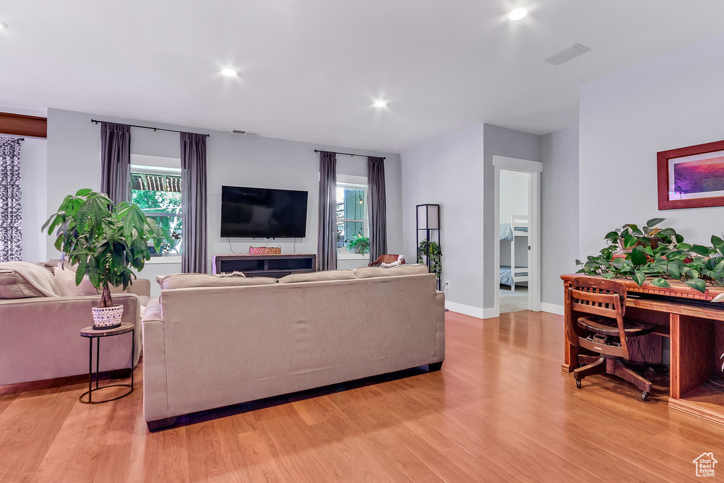 Living room with light wood-type flooring, recessed lighting, and baseboards