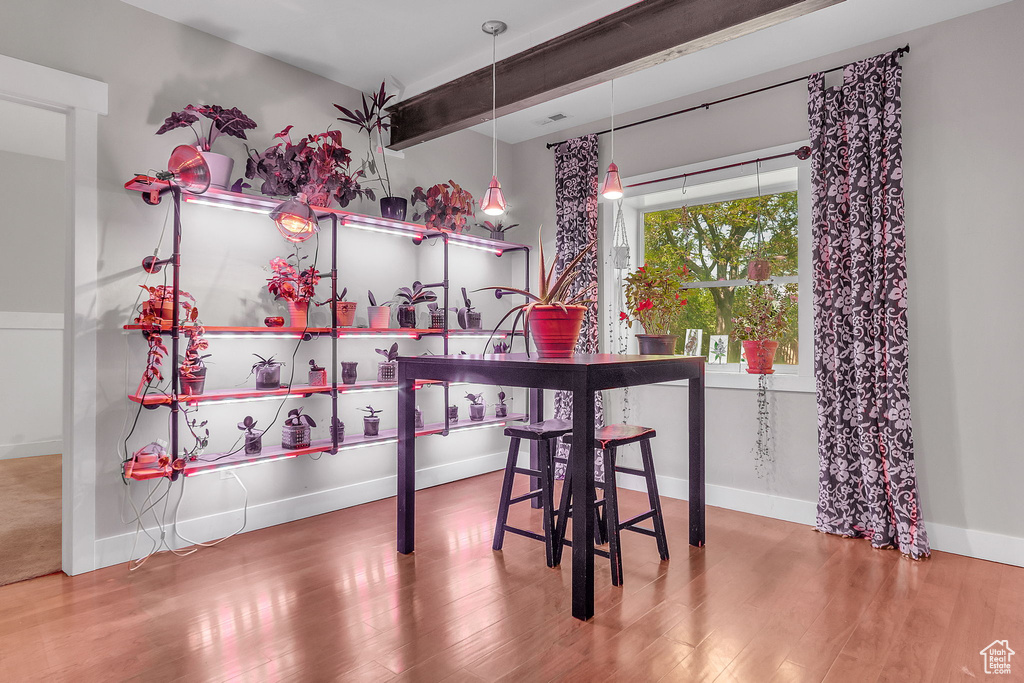 Dining area featuring wood finished floors, baseboards, and beamed ceiling