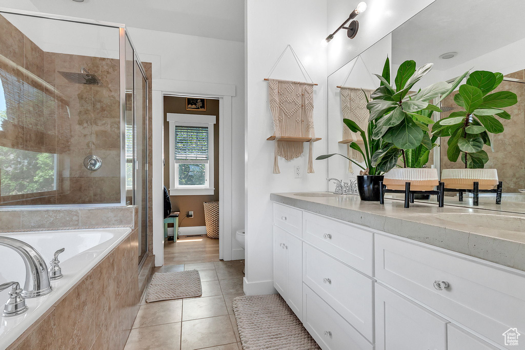 Full bathroom featuring a shower stall, a bath, tile patterned floors, double vanity, and toilet