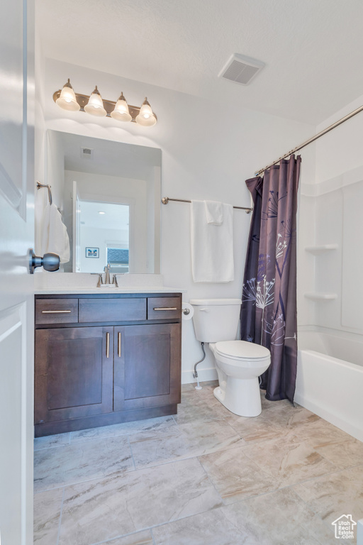 Bathroom featuring toilet, vanity, and shower / tub combo with curtain