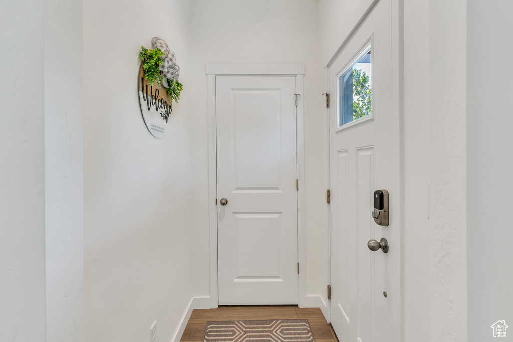 Doorway with light wood-style flooring and baseboards