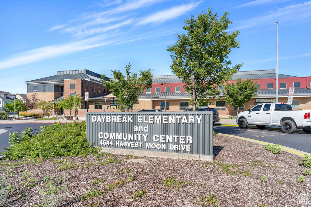 Community / neighborhood sign with uncovered parking and a residential view