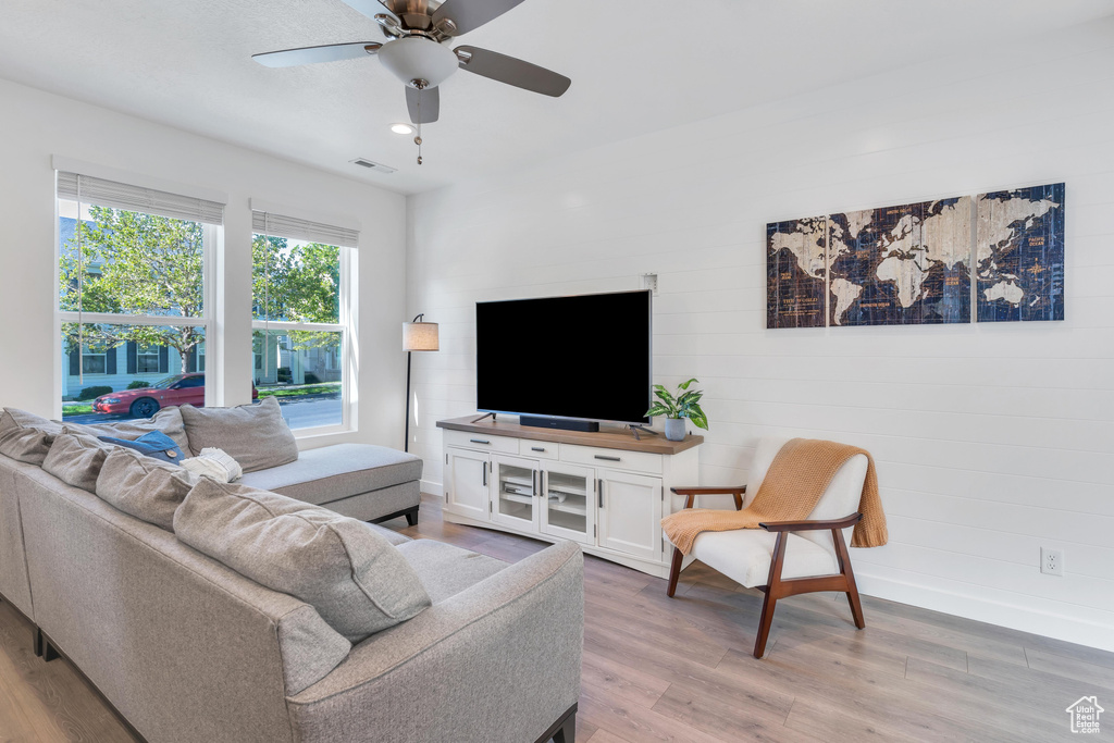 Living room with light wood-style flooring, ceiling fan, baseboards, and recessed lighting