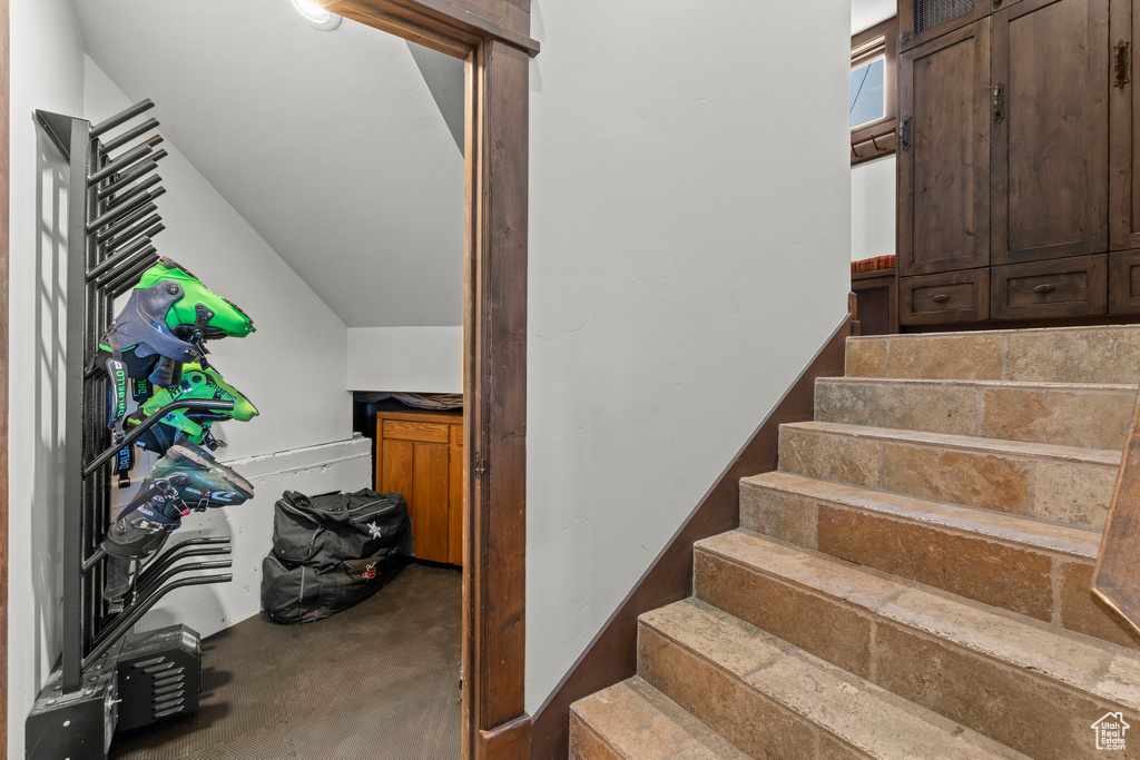 Staircase with concrete floors and lofted ceiling