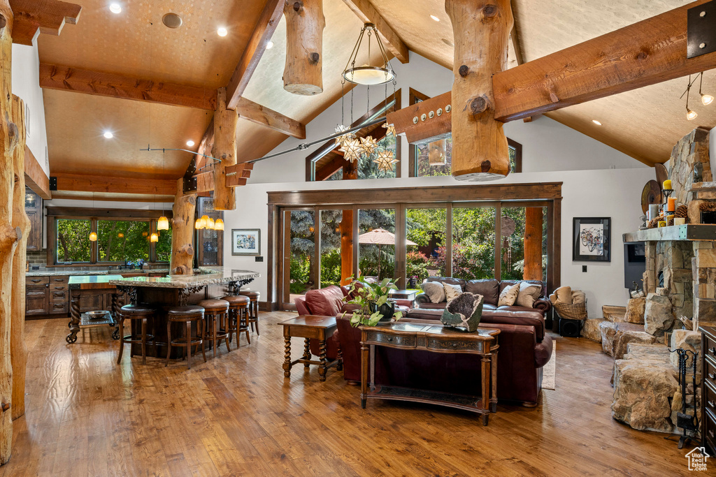 Living area with beamed ceiling, high vaulted ceiling, hardwood / wood-style floors, and recessed lighting