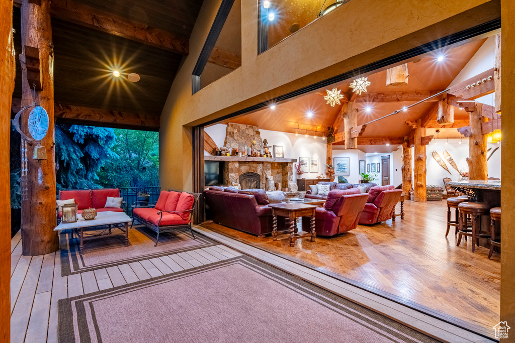 Living room with hardwood / wood-style flooring, beamed ceiling, and high vaulted ceiling