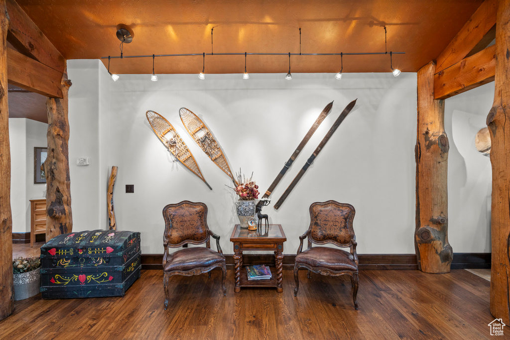 Living area featuring wood finished floors, baseboards, and rail lighting
