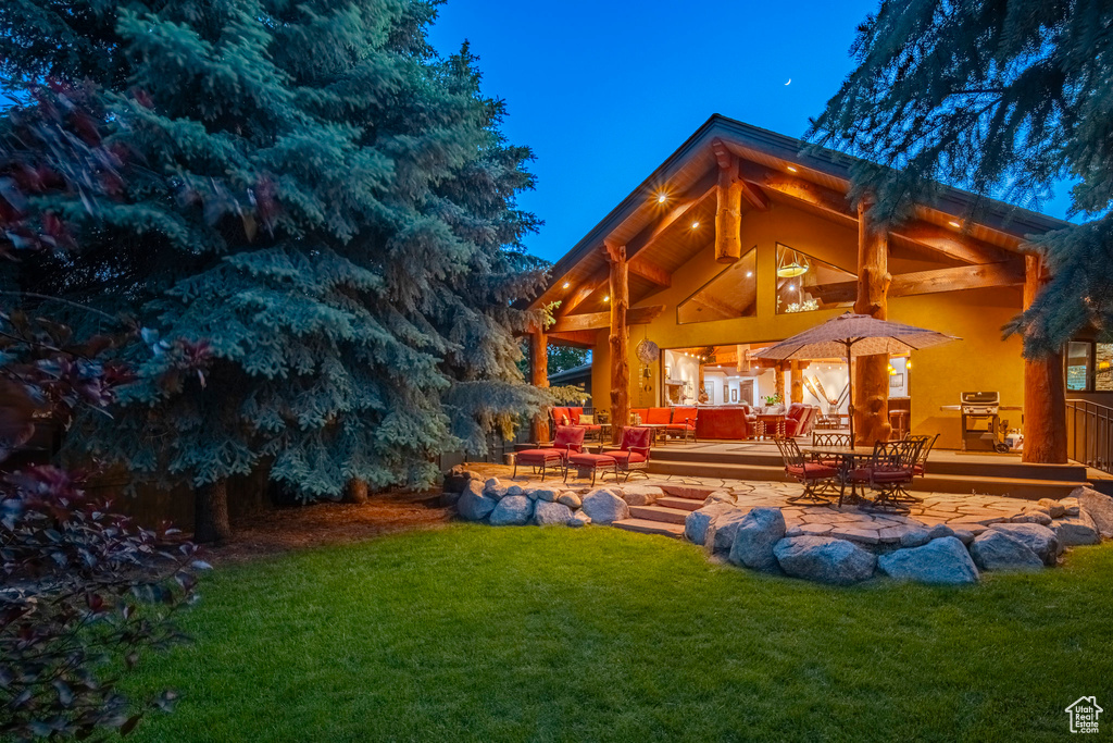 Rear view of property featuring a lawn, a patio area, and an outdoor hangout area