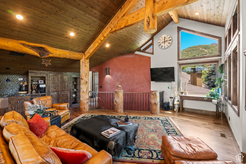 Living room featuring high vaulted ceiling, wood finished floors, wood ceiling with exposed beams, and recessed lighting