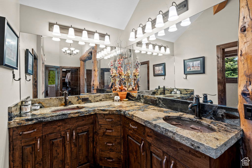 Full bath featuring double vanity and vaulted ceiling