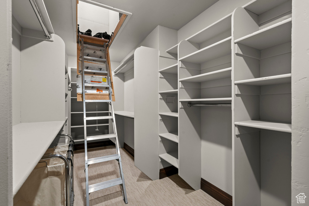 Walk in closet with light carpet