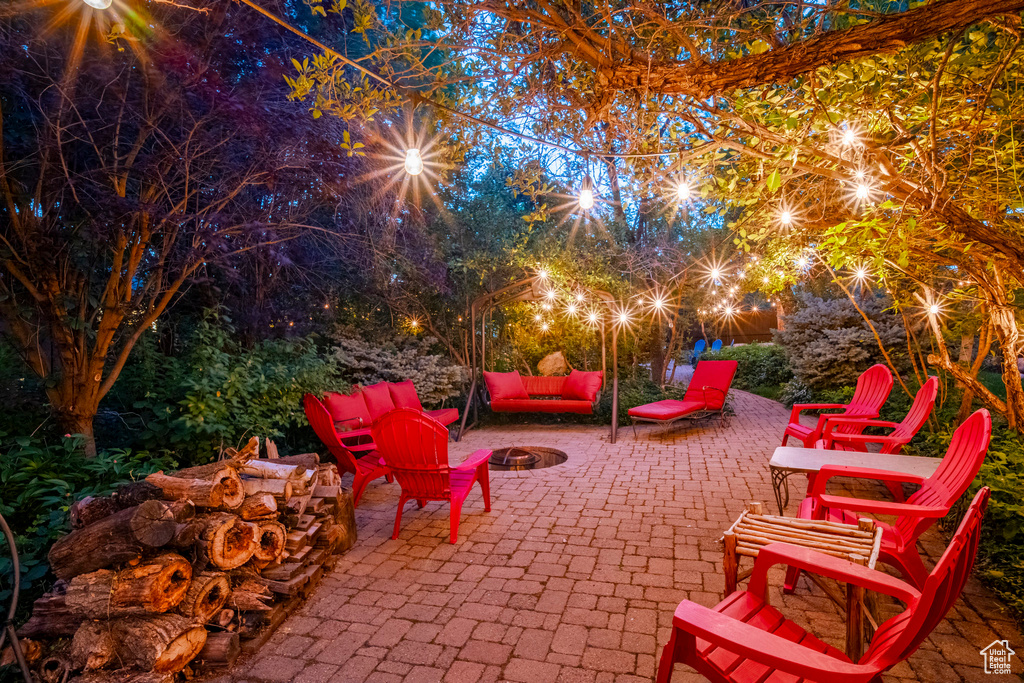 Patio at night featuring a fire pit and a patio area