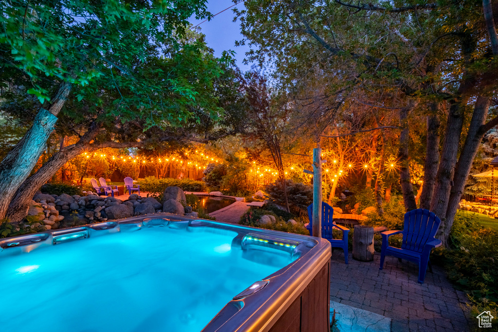View of pool with a hot tub and a patio area