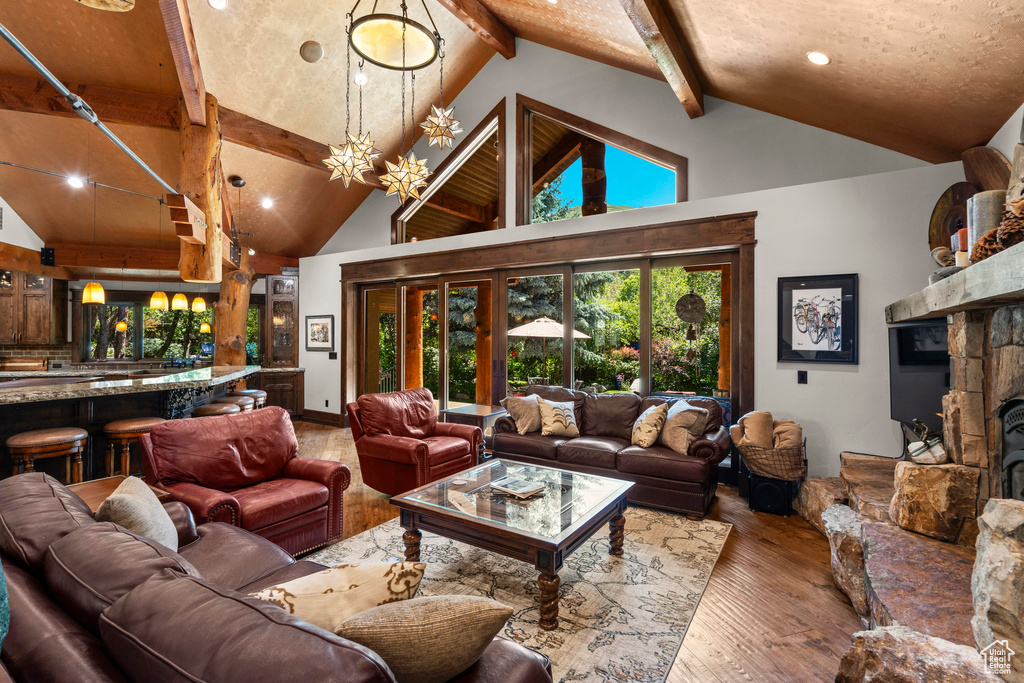 Living area featuring beam ceiling, hardwood / wood-style flooring, recessed lighting, and high vaulted ceiling