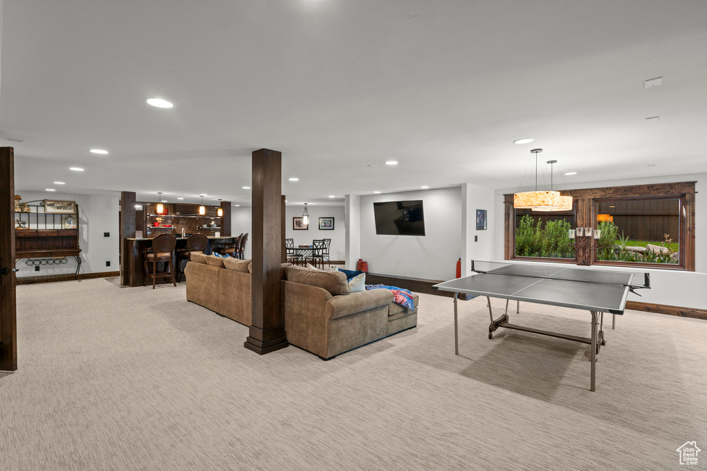 Carpeted living area with bar area, recessed lighting, and baseboards