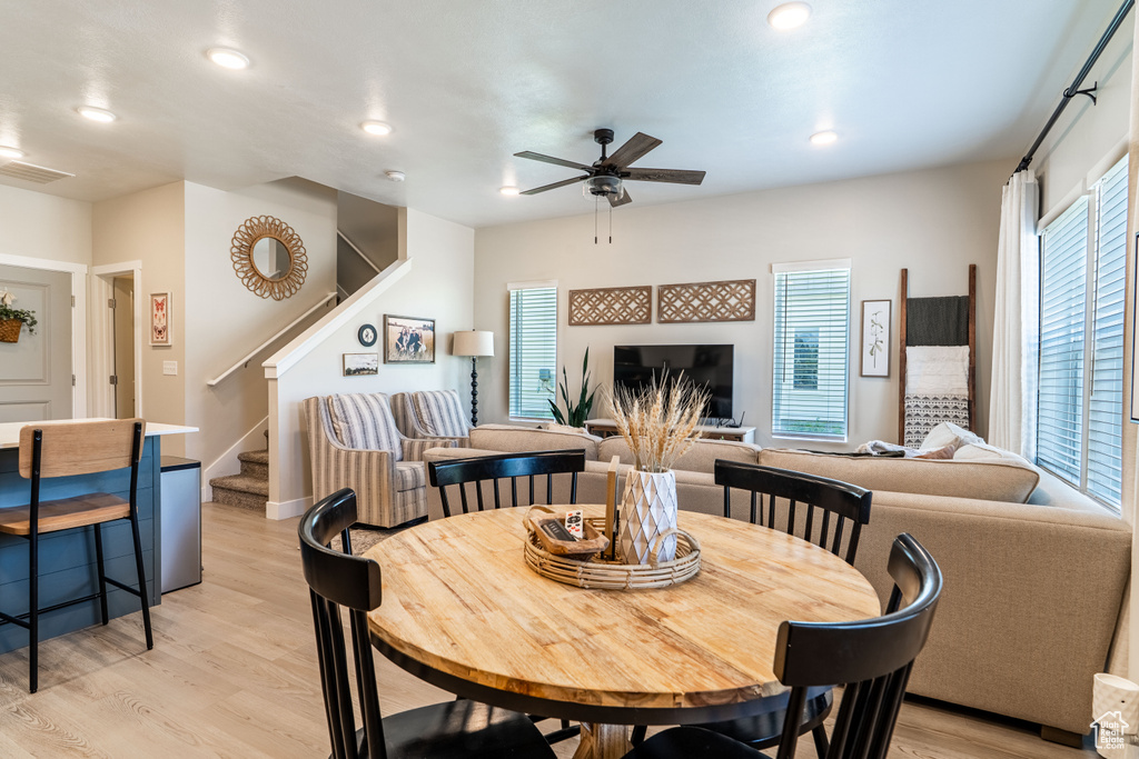 Dining room with light wood-style floors, stairway, ceiling fan, plenty of natural light, and recessed lighting