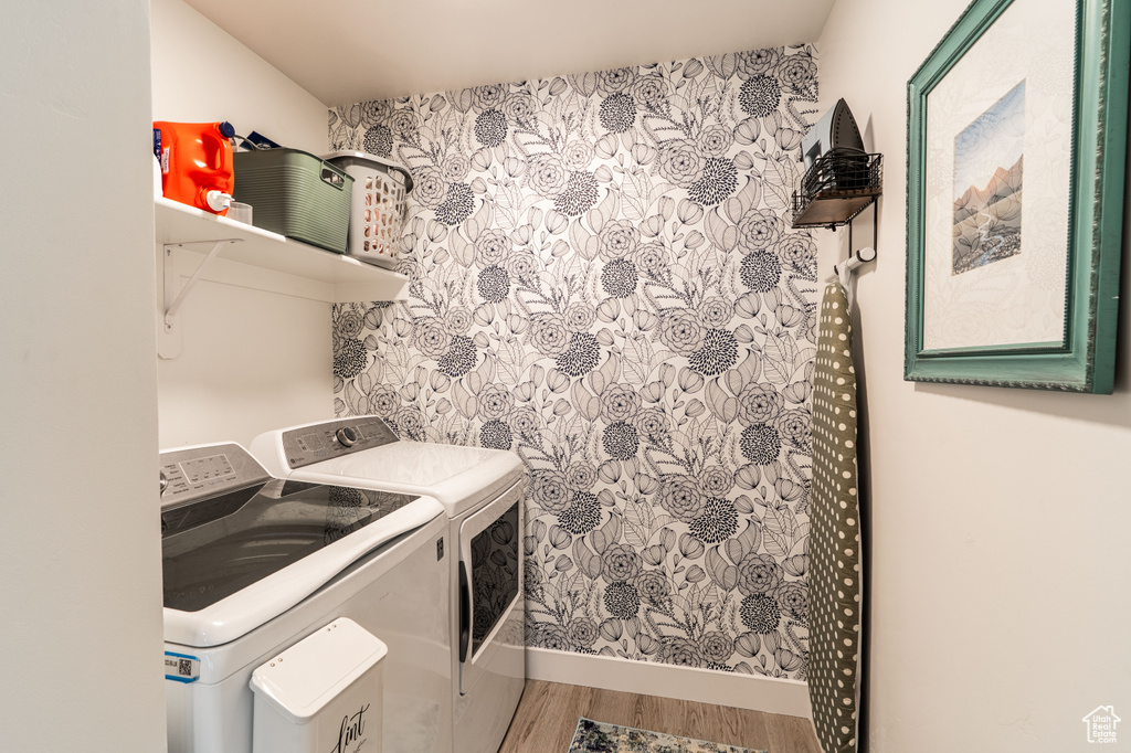 Laundry room with washing machine and dryer and wood finished floors