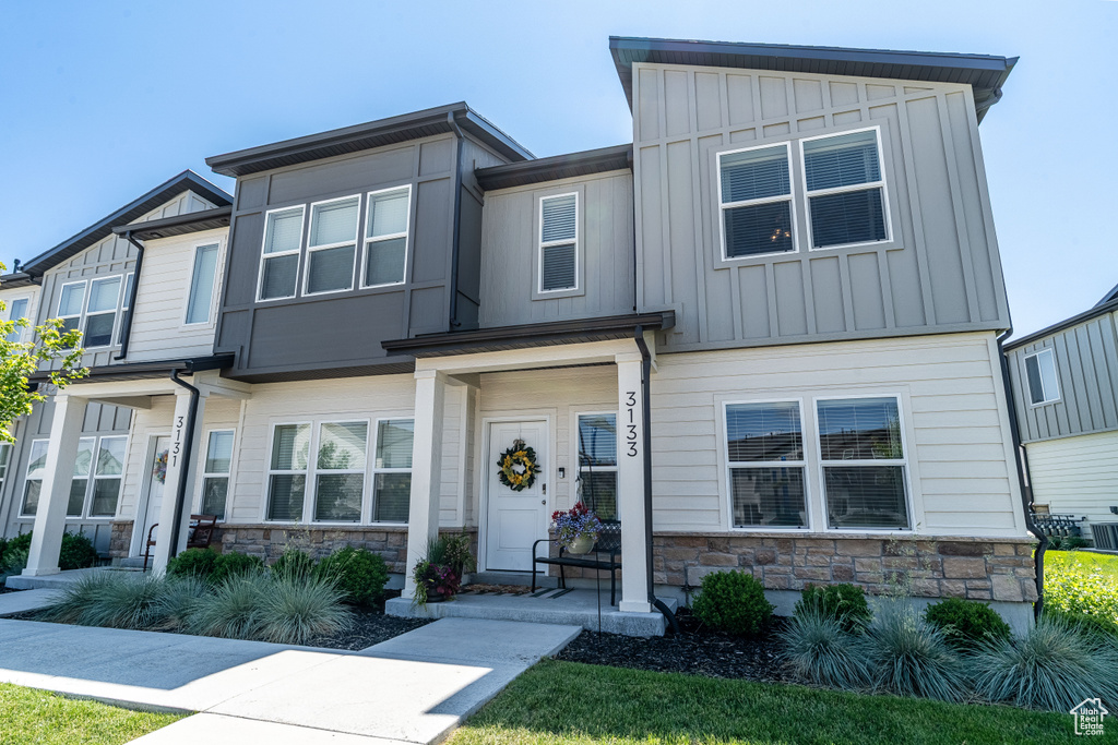 View of front of property featuring stone siding and board and batten siding