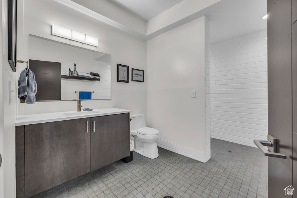 Bathroom with vanity, toilet, tile patterned flooring, and baseboards