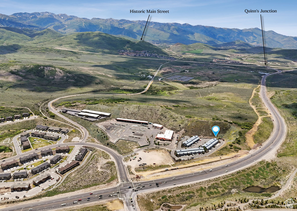 Aerial view of property and surrounding area featuring a mountainous background