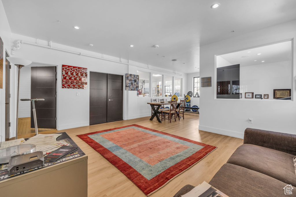 Living room with light wood-type flooring, recessed lighting, and baseboards