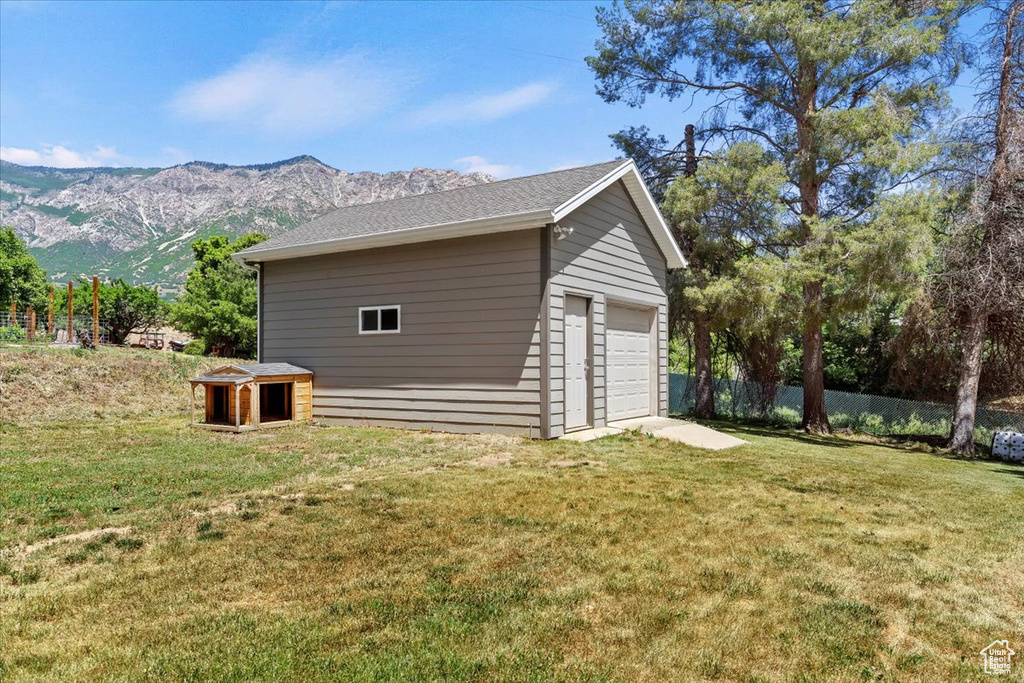 View of side of home featuring a garage, an outbuilding, and a mountain view