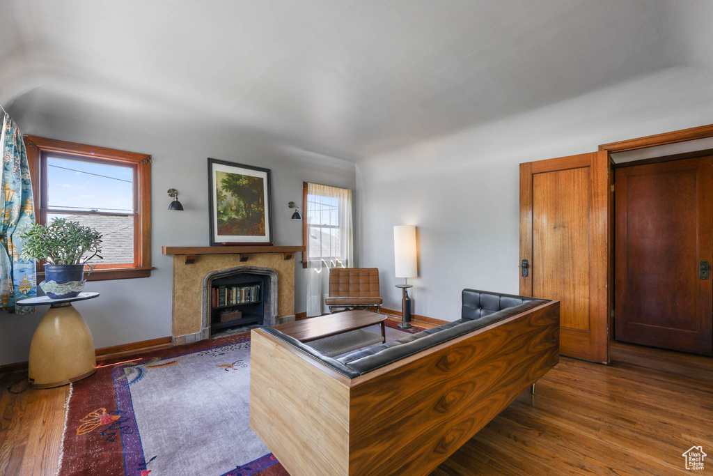 Living room featuring a glass covered fireplace, wood finished floors, and baseboards