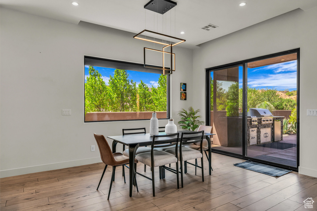 Dining room featuring hardwood / wood-style flooring, baseboards, recessed lighting, and a chandelier