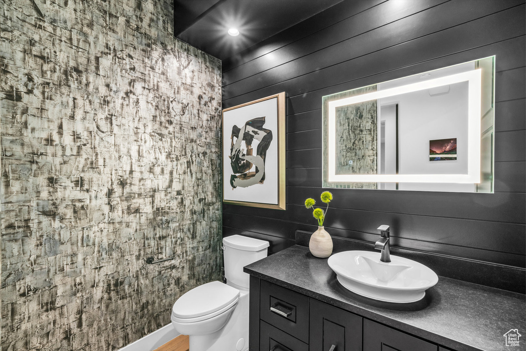 Bathroom featuring vanity, toilet, and decorative backsplash