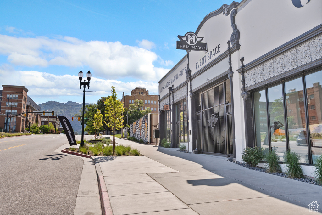View of asphalt street with sidewalks, street lighting, a mountain view, and curbs