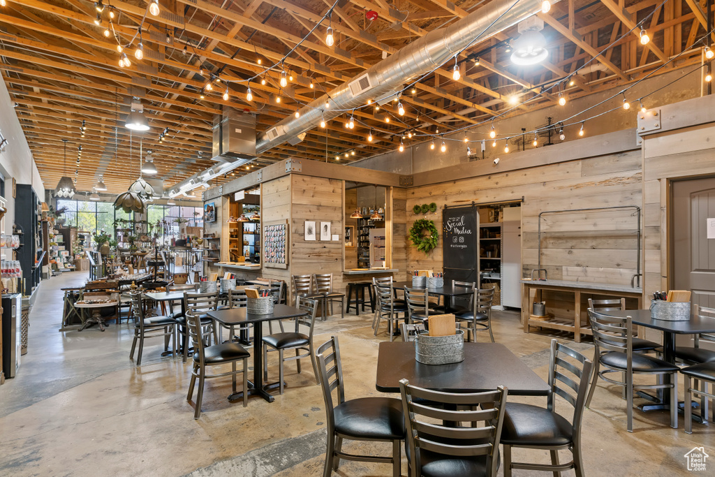 Dining area featuring concrete flooring and wood walls