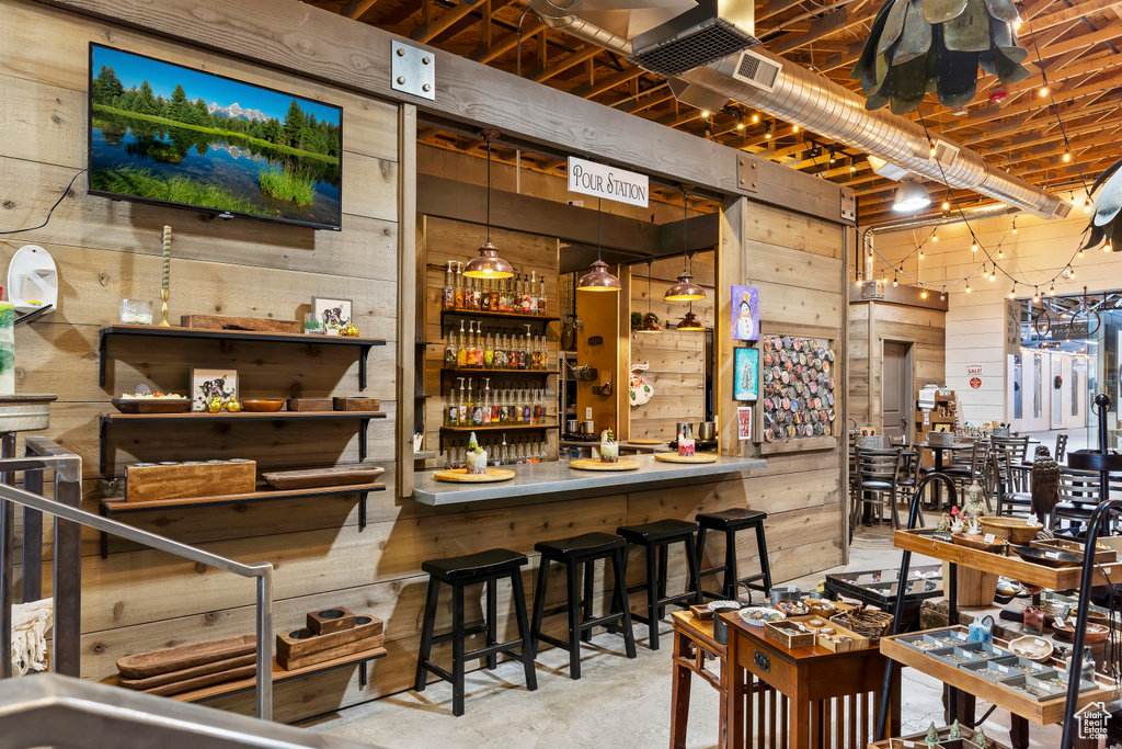 Indoor dry bar featuring concrete floors and wooden walls