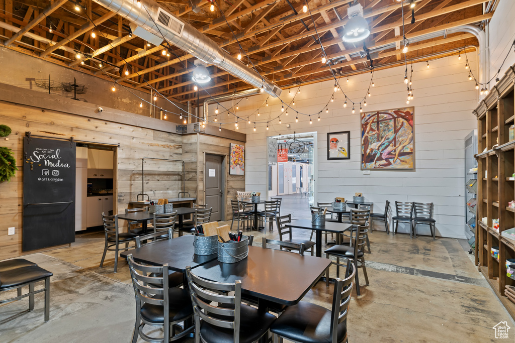 Dining space featuring concrete floors and wood walls