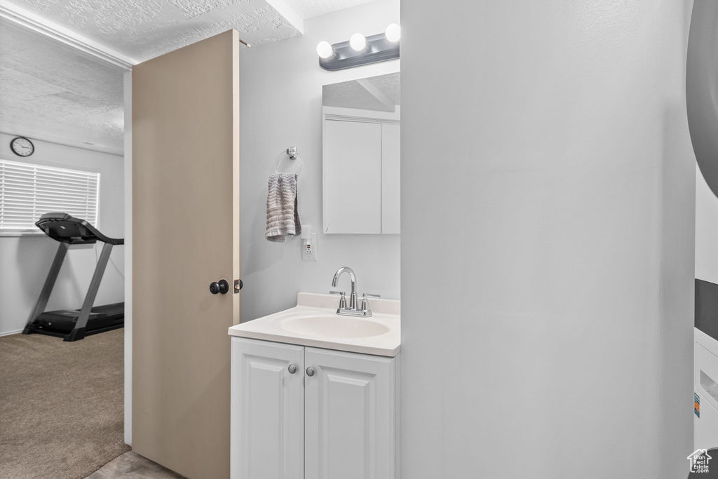 Bathroom with a textured ceiling and vanity