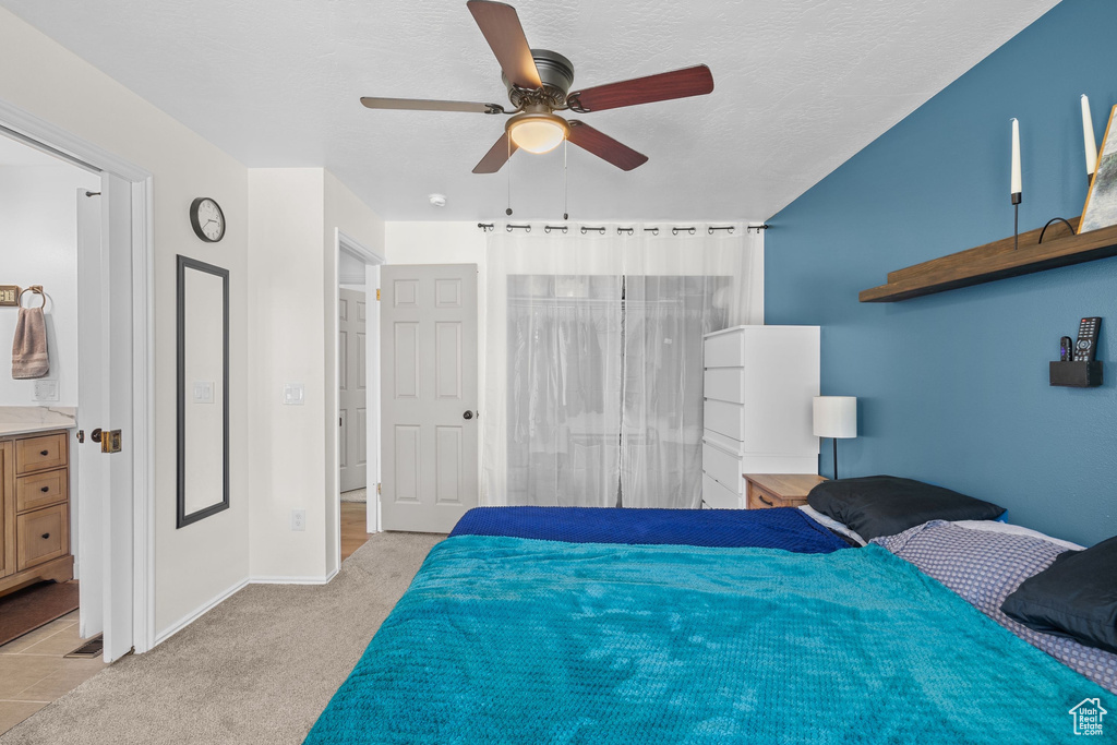 Bedroom featuring light carpet, baseboards, and ceiling fan